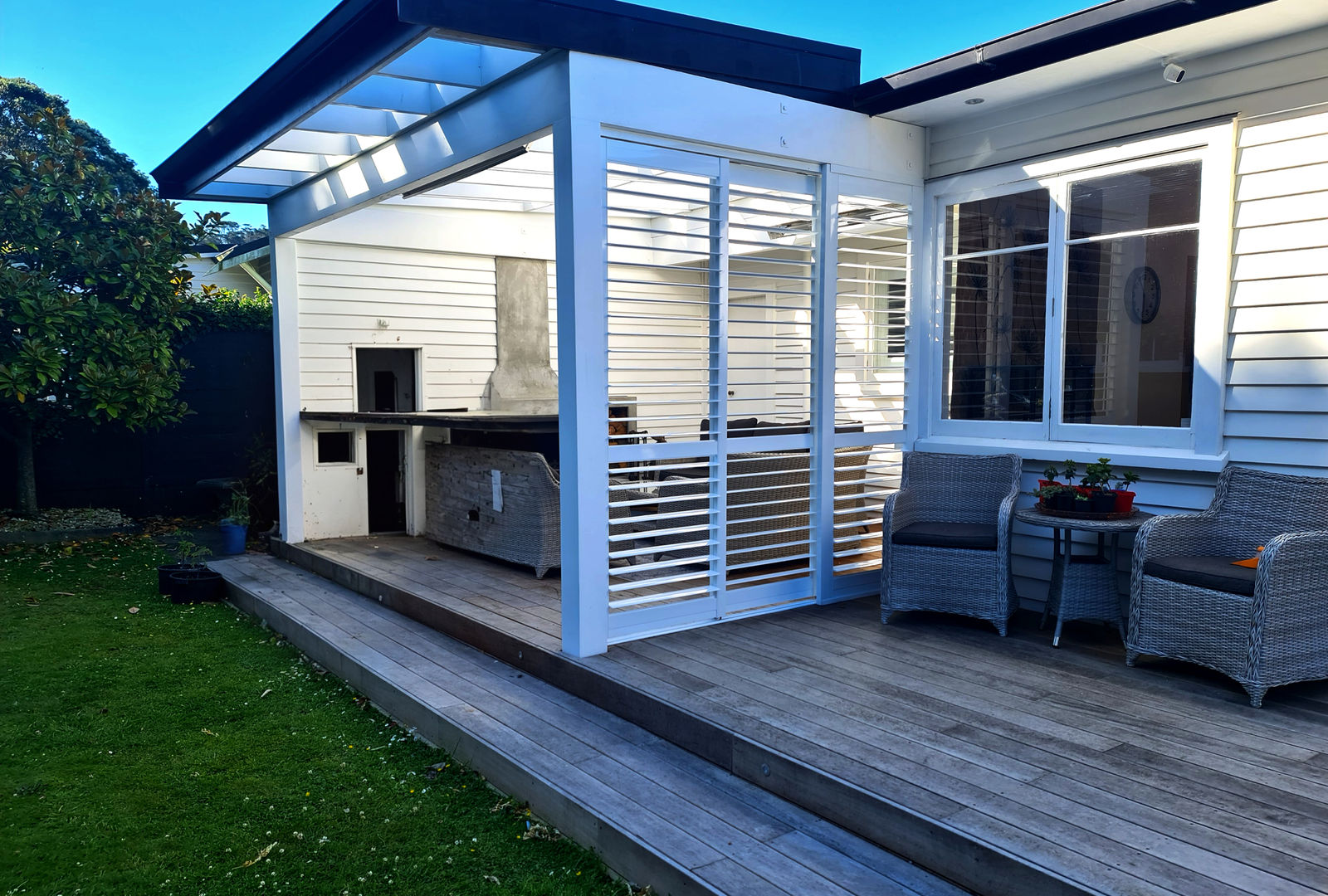 White aluminium exterior shutters on a Wellington deck acting as a windbreak while filtering afternoon sun